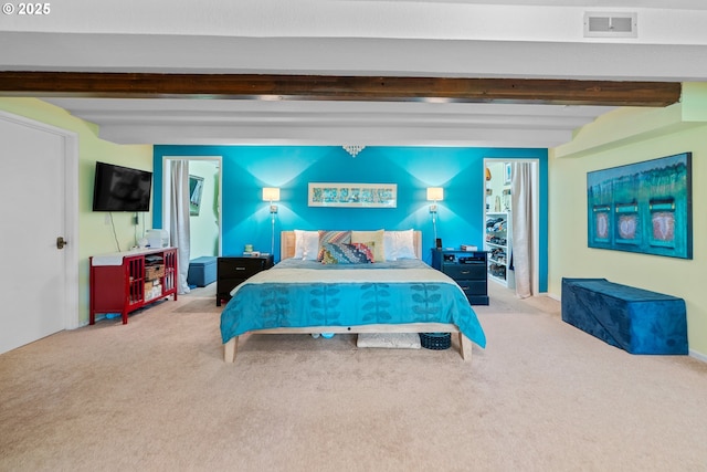 carpeted bedroom with beamed ceiling