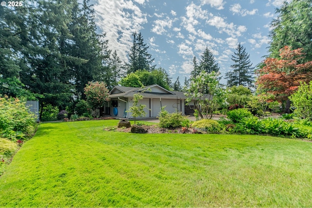 view of green lawn featuring an attached garage