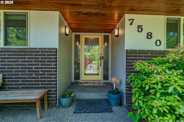 view of exterior entry with brick siding