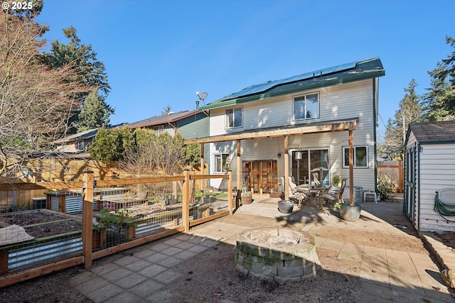 back of property featuring a patio area, a shed, and an outdoor fire pit