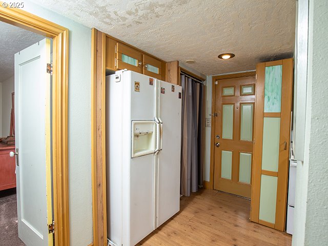 4930 SE 113th Ave, Portland, OR 97266 - kitchen with white refrigerator with ice dispenser, a textured ceiling, and light wood finished floors