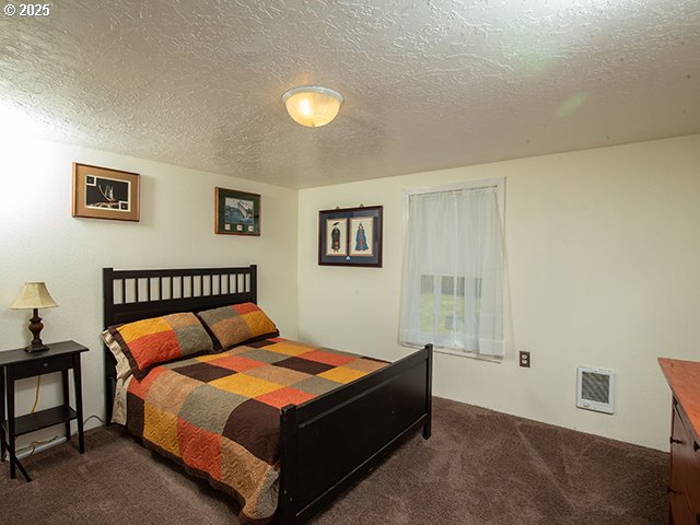 4930 SE 113th Ave, Portland, OR 97266 - bedroom with dark carpet, a textured ceiling, and heating unit