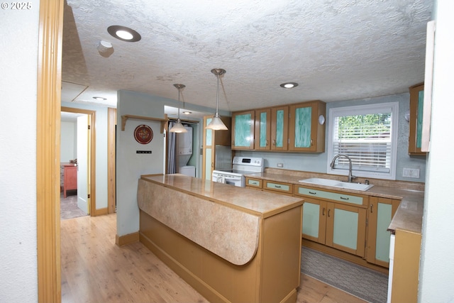4930 SE 113th Ave, Portland, OR 97266 - kitchen with a sink, stacked washer / drying machine, electric range, light wood-style flooring, and light countertops
