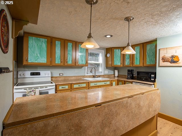 4930 SE 113th Ave, Portland, OR 97266 - kitchen featuring white range with electric cooktop, black microwave, a sink, brown cabinets, and light wood-style flooring