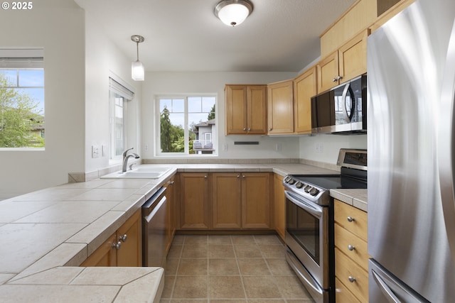 1874 NE 101st Ave Unit 202, Hillsboro, OR 97006 - kitchen with stainless steel appliances, a sink, tile countertops, and plenty of natural light