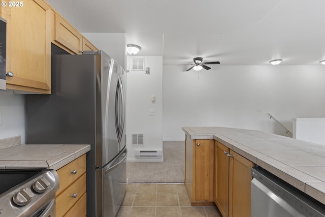 1874 NE 101st Ave Unit 202, Hillsboro, OR 97006 - kitchen with appliances with stainless steel finishes, a ceiling fan, tile counters, and light colored carpet
