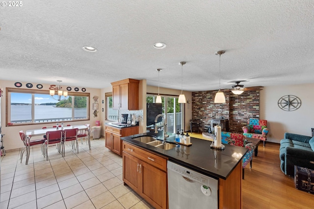 94020 E Shore Dr, North Bend, OR 97459 - kitchen with dishwashing machine, a sink, open floor plan, dark countertops, and a textured ceiling