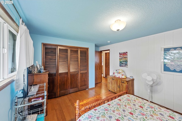 94020 E Shore Dr, North Bend, OR 97459 - bedroom with wood finished floors, a closet, and a textured ceiling