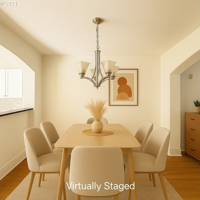 836 NW 118th Ave Unit 104, Portland, OR 97229 - dining room featuring a chandelier, wood finished floors, and baseboards