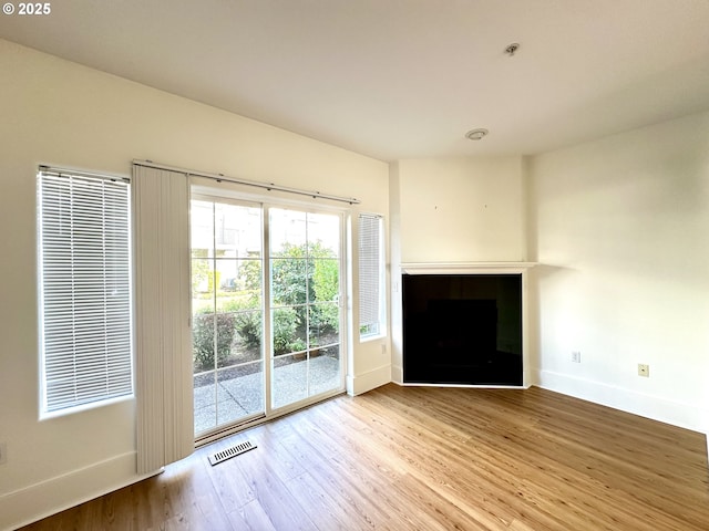 836 NW 118th Ave Unit 104, Portland, OR 97229 - unfurnished living room with baseboards, wood finished floors, visible vents, and a fireplace