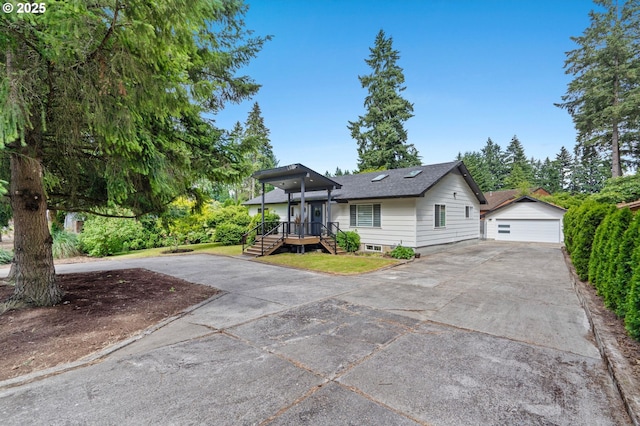 view of front of home featuring a shingled roof, an outdoor structure, and a detached garage