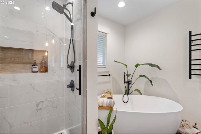 bathroom with a freestanding bath and a tile shower