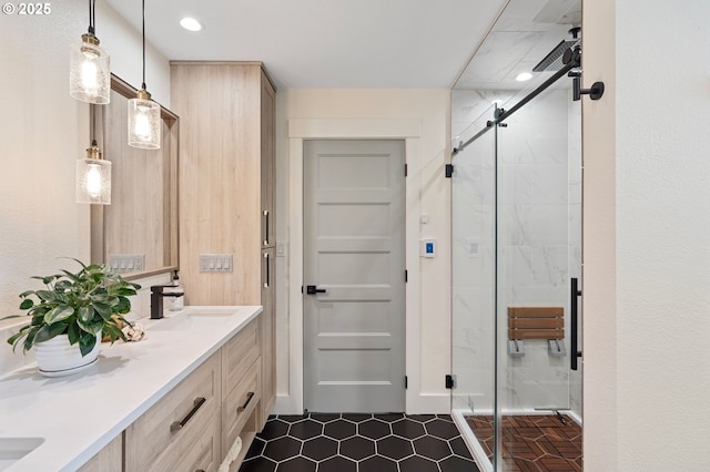 bathroom featuring a sink, a marble finish shower, and double vanity