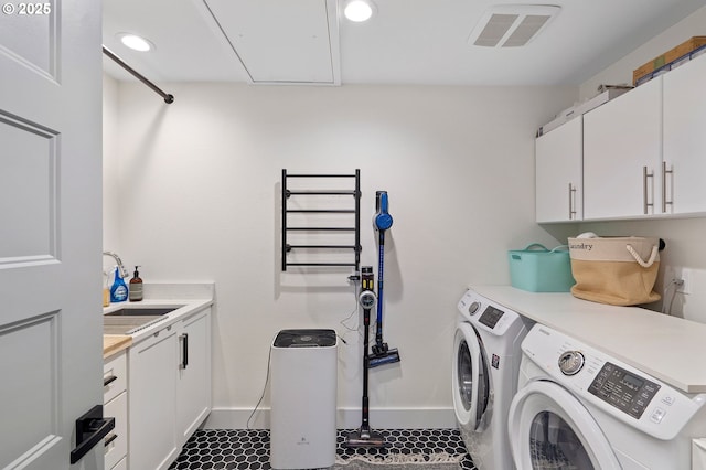 laundry area featuring visible vents, cabinet space, attic access, washing machine and dryer, and a sink