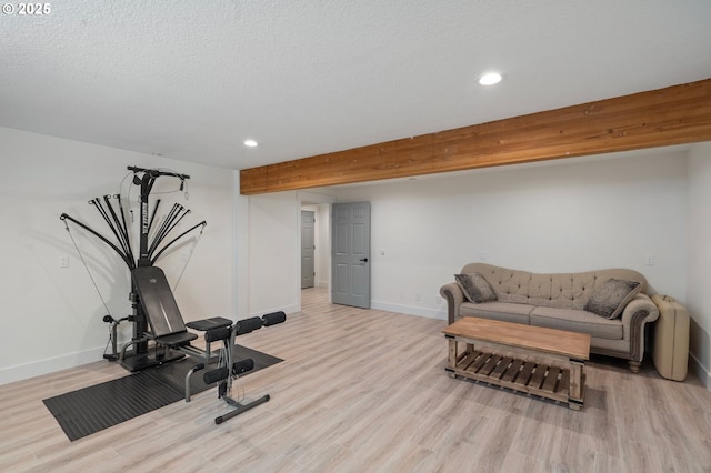 exercise room with recessed lighting, a textured ceiling, baseboards, and wood finished floors