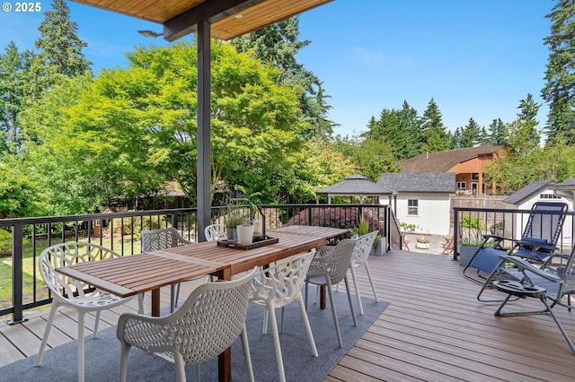 wooden deck with a gazebo and outdoor dining area