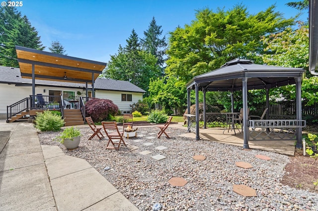 view of yard featuring a wooden deck, a patio, and a gazebo