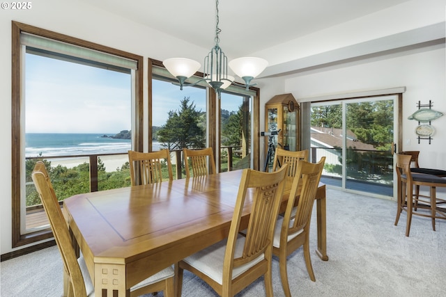 105 NW 45th St Unit 4, Newport, OR 97365 - dining space with a notable chandelier, a water view, and light colored carpet