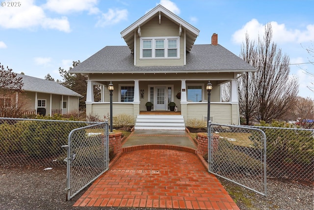 bungalow-style house featuring a fenced front yard, covered porch, a shingled roof, a gate, and a chimney