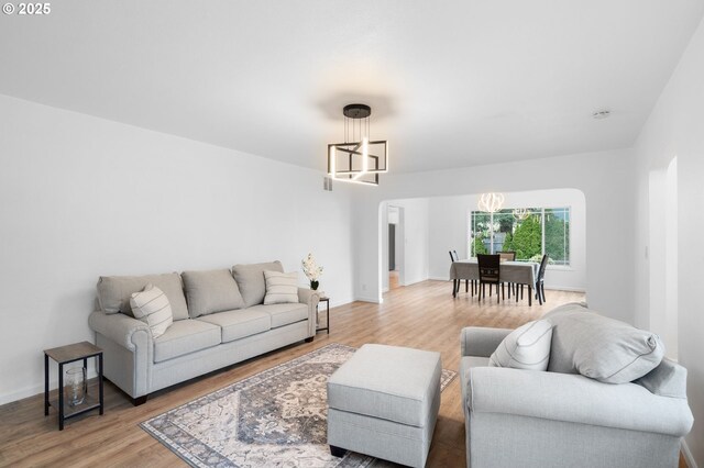 13332 SE Harold St, Portland, OR 97236 - living room featuring a chandelier, light wood-style floors, and baseboards