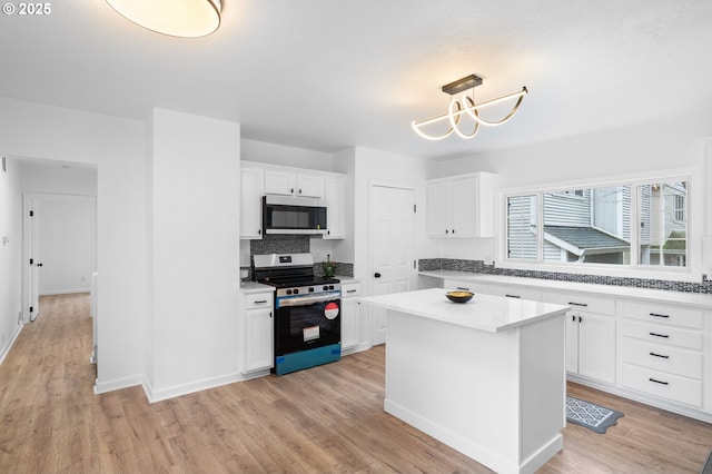 13332 SE Harold St, Portland, OR 97236 - kitchen with stainless steel appliances, backsplash, white cabinets, and light wood-style floors
