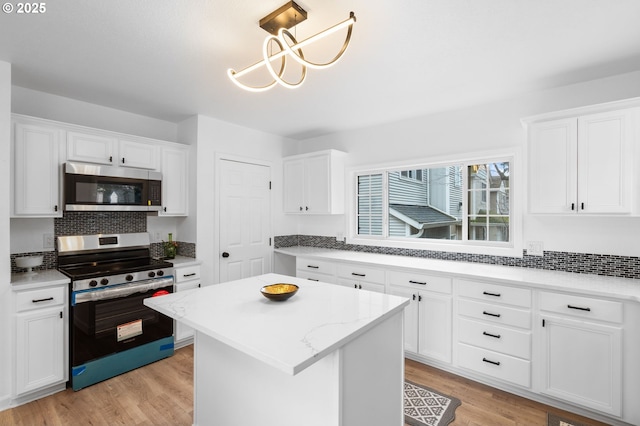 13332 SE Harold St, Portland, OR 97236 - kitchen featuring appliances with stainless steel finishes, backsplash, and white cabinetry