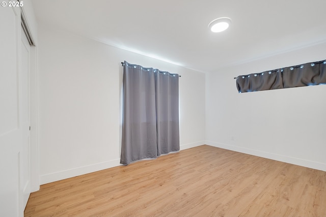 empty room with baseboards and wood finished floors