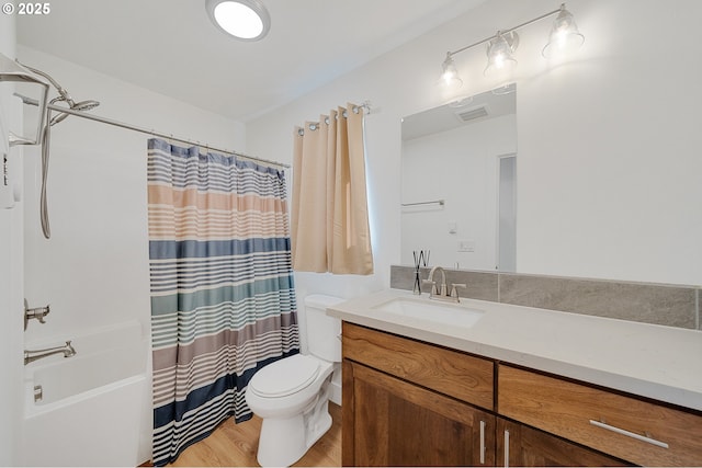 full bathroom with toilet, wood finished floors, vanity, visible vents, and shower / bath combo with shower curtain