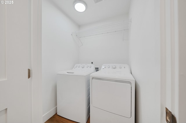 laundry room featuring washer and dryer, laundry area, visible vents, and wood finished floors