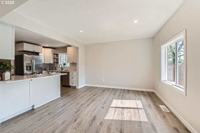 4106 SE 122nd Ave, Portland, OR 97236 - kitchen featuring stainless steel appliances, light wood-type flooring, a peninsula, light countertops, and open shelves
