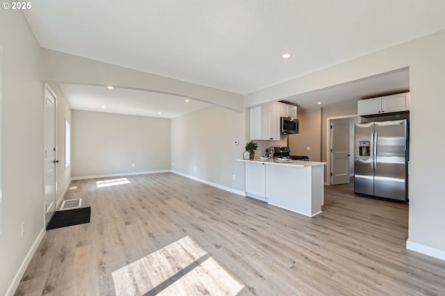4106 SE 122nd Ave, Portland, OR 97236 - unfurnished living room featuring light wood-style flooring, recessed lighting, and arched walkways