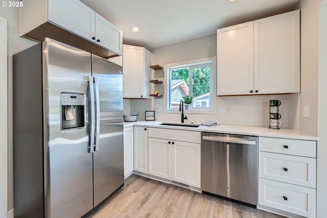 4106 SE 122nd Ave, Portland, OR 97236 - kitchen with appliances with stainless steel finishes, light wood finished floors, white cabinetry, light countertops, and recessed lighting