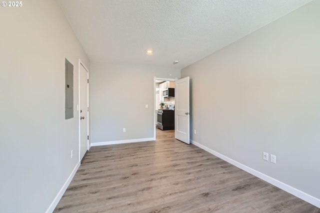 4106 SE 122nd Ave, Portland, OR 97236 - unfurnished bedroom featuring light wood-type flooring, a textured ceiling, electric panel, and recessed lighting
