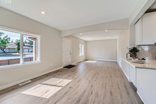 4106 SE 122nd Ave, Portland, OR 97236 - unfurnished living room with arched walkways, light wood finished floors, and recessed lighting