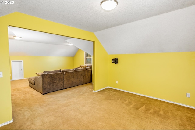 bonus room featuring light colored carpet, lofted ceiling, and a textured ceiling