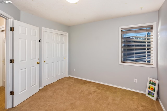 unfurnished bedroom featuring light colored carpet and a closet