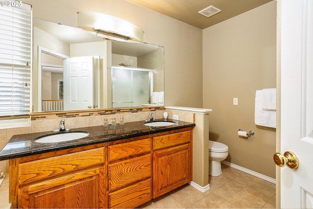 bathroom with vanity, decorative backsplash, tile patterned floors, and walk in shower