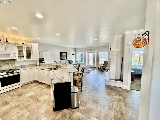 842 Chetco Point Ter, Brookings, OR 97415 - kitchen featuring white appliances, a peninsula, ornamental molding, a kitchen breakfast bar, and white cabinets