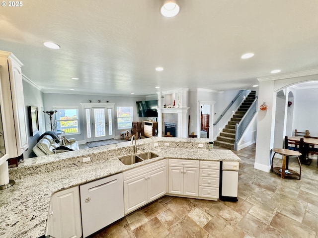 842 Chetco Point Ter, Brookings, OR 97415 - kitchen with white dishwasher, a tiled fireplace, crown molding, arched walkways, and recessed lighting