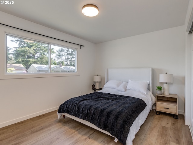 bedroom featuring light wood-style floors and baseboards