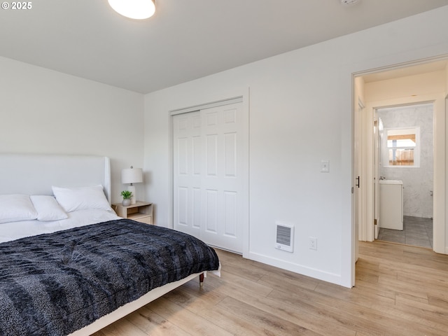 bedroom with light wood-type flooring, baseboards, and a closet