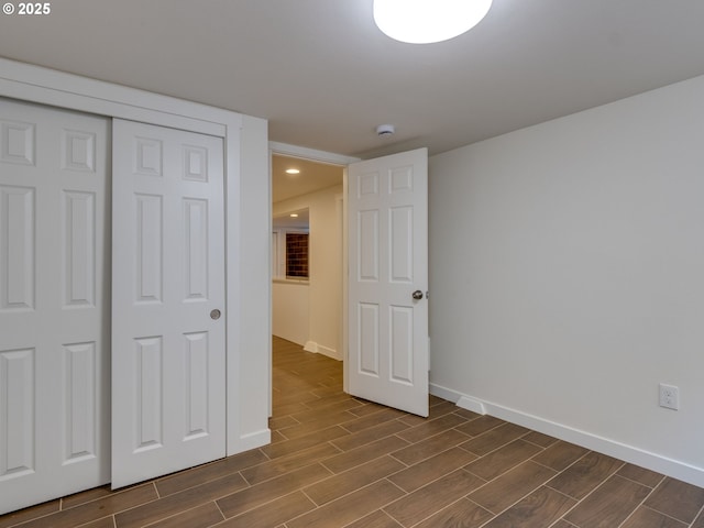 unfurnished bedroom with dark wood finished floors, baseboards, a closet, and recessed lighting