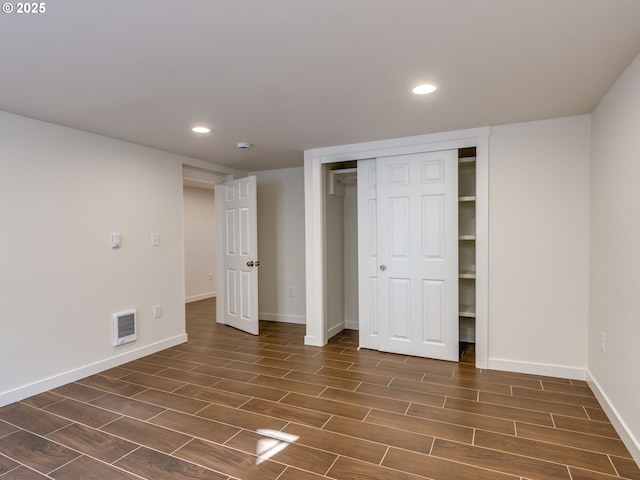 unfurnished bedroom featuring dark wood finished floors, recessed lighting, baseboards, and a closet