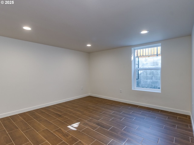 spare room featuring recessed lighting, baseboards, and wood tiled floors