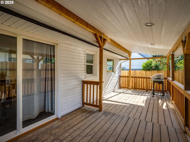 wooden terrace with fence and a grill