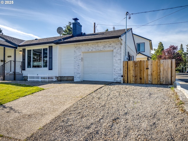 view of front of home with an attached garage, stone siding, fence, driveway, and a chimney