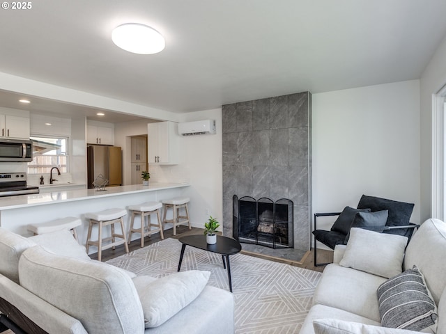 living area featuring a wall unit AC, a fireplace, wood finished floors, and recessed lighting