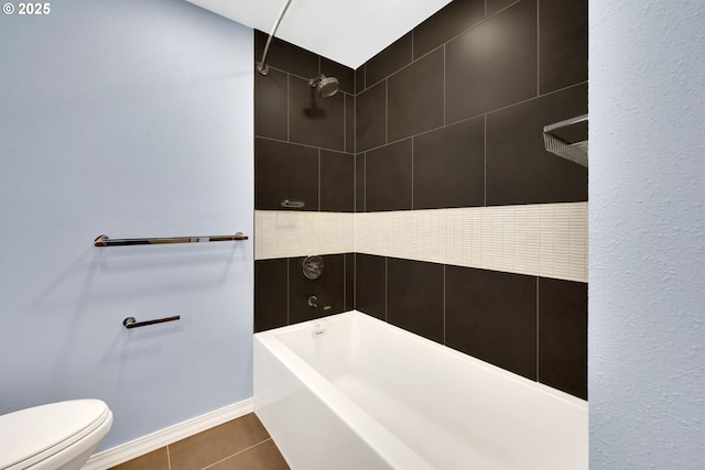 bathroom featuring toilet, tiled shower / bath combo, and tile patterned flooring