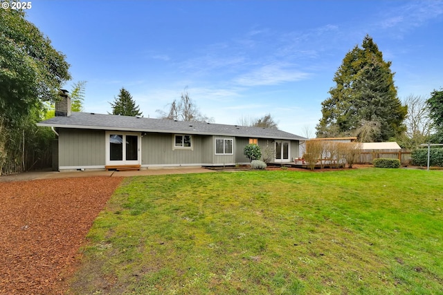 back of house featuring a deck and a lawn