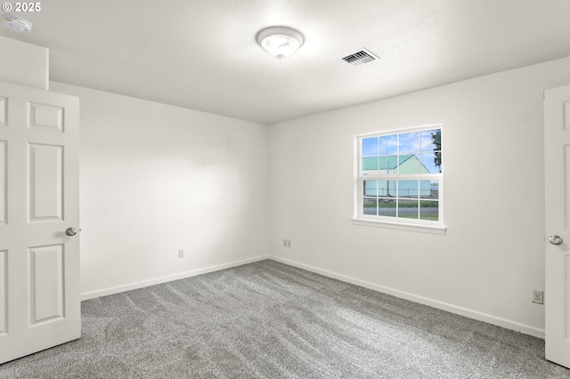 spare room featuring a smoke detector, carpet, and baseboards